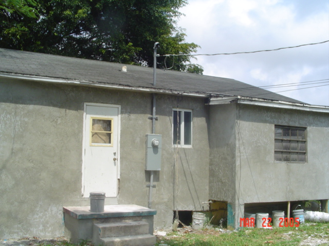 Rear of home during rehabilitation with cement stucco finish