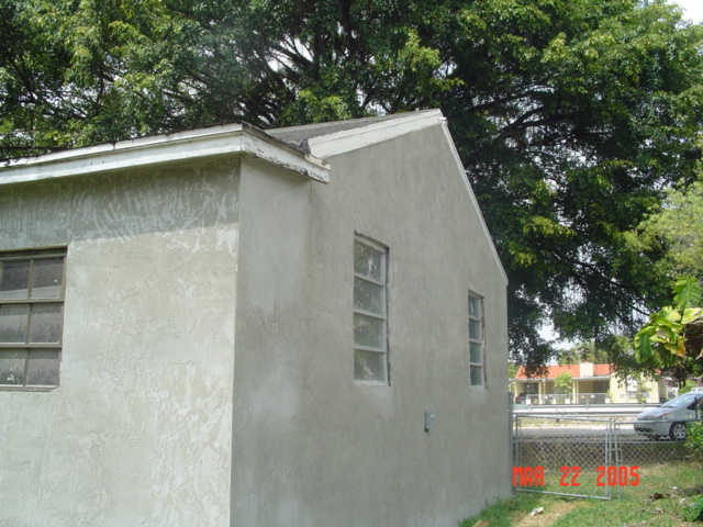 Side of home during rehabilitation with cement stucco finish