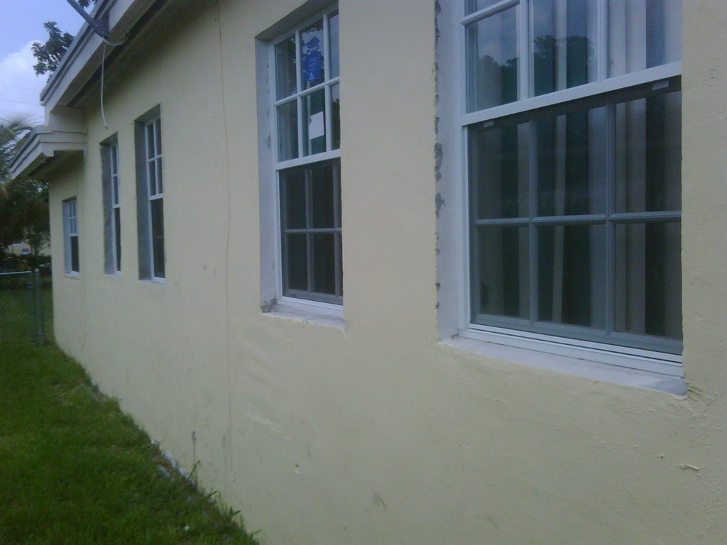 Before photo of R.E.O. property with windows & shutters compliance violations