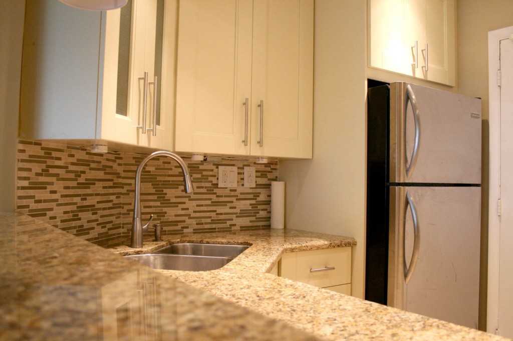 Modern multi-color tile backsplash, cabinets and marble counter-top