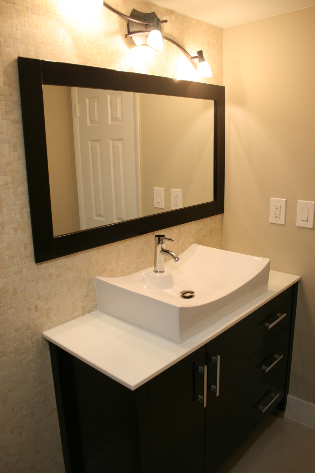 Remodeled bathroom with modern sink and stone vanity top