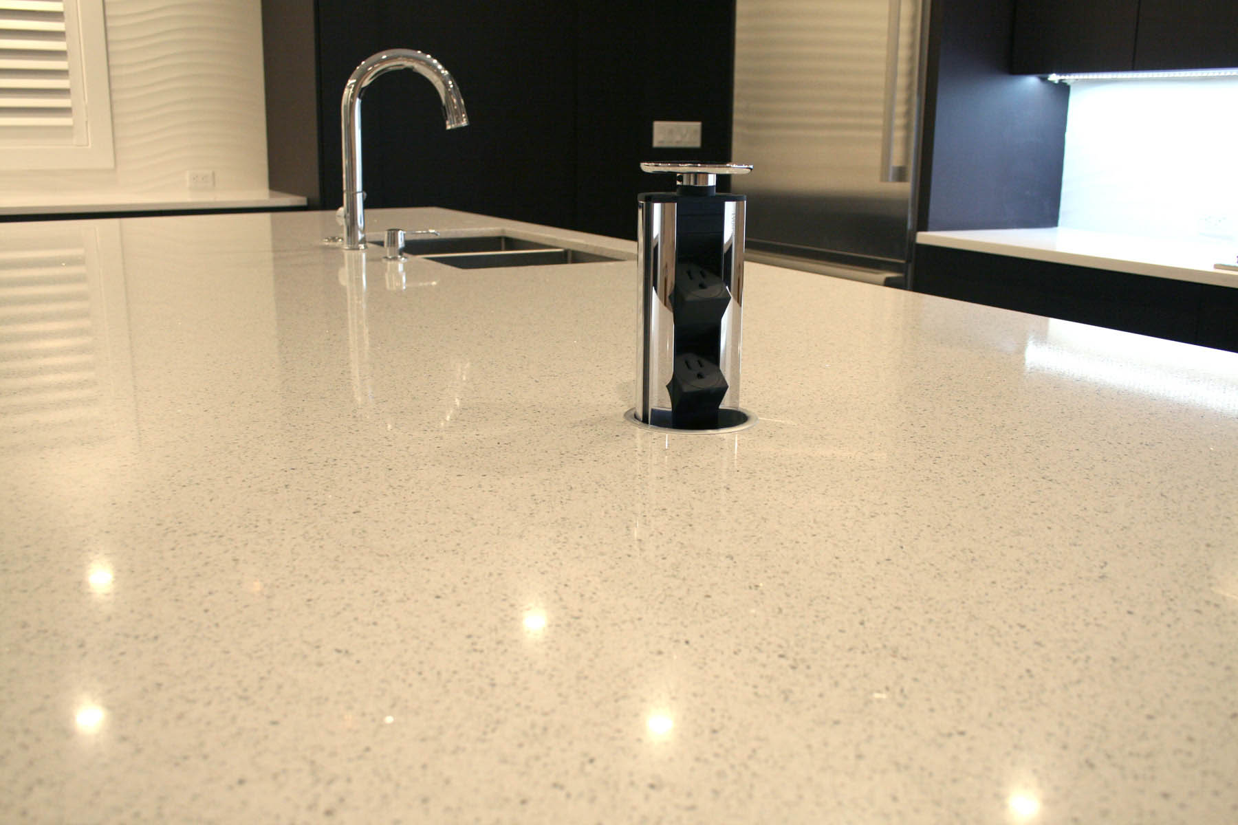 White Quartz Counter Top with Concealed Pop-Up Electrical Outlets