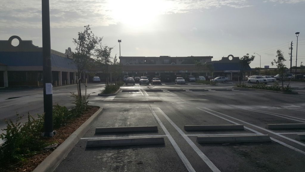 Completed new parking lot with new concrete curbs, stop signs and handicap signs