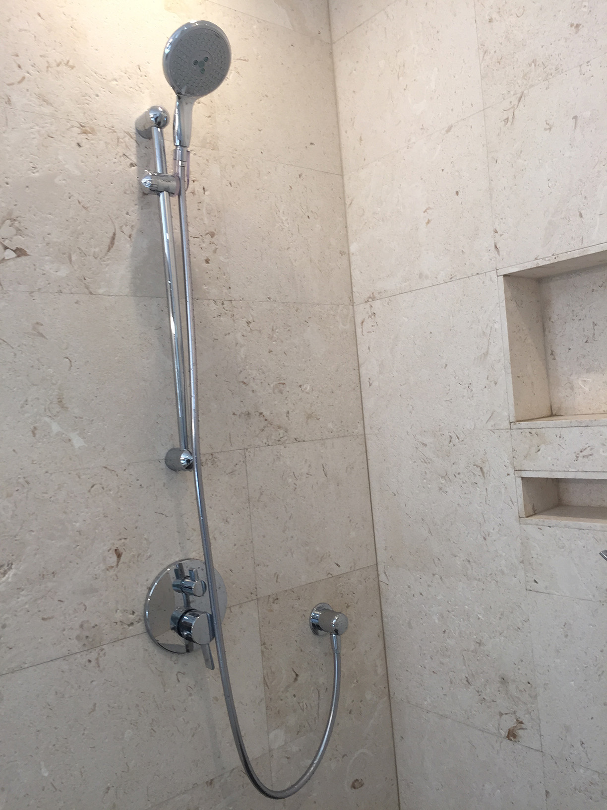 Travertine wall tile & handheld shower head