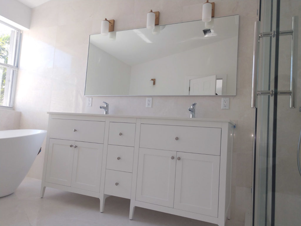 Remodeled master bathroom with freestanding bathtub and shower enclosure with sliding glass door