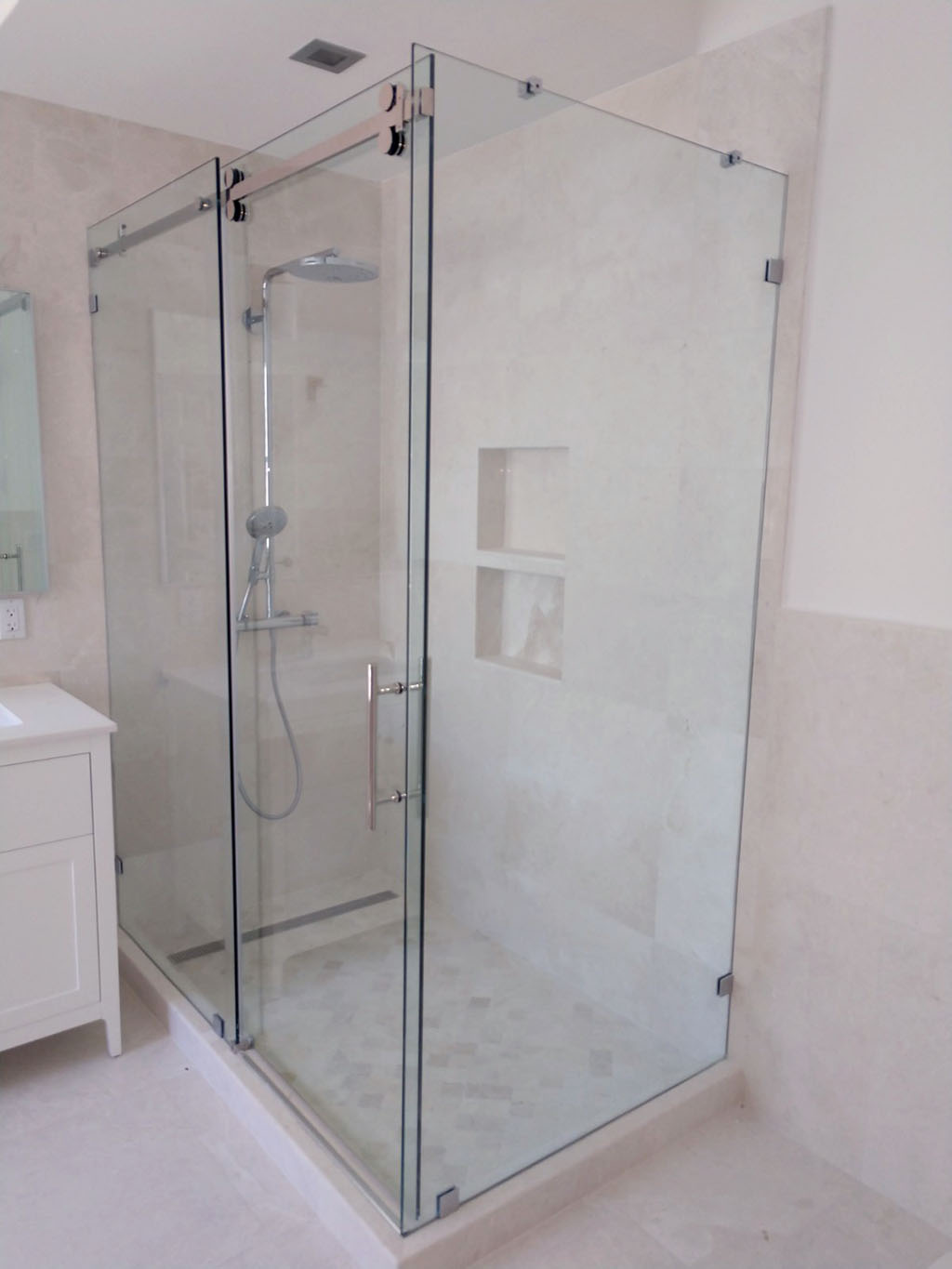 Remodeled master bathroom with sliding glass door at shower enclosure