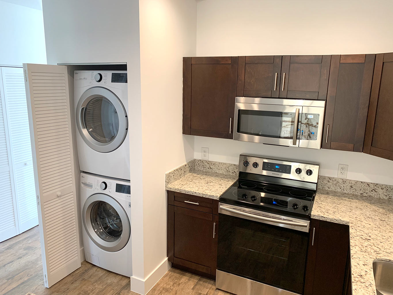 After photo of kitchen and laundry closet with stackable washer and dryer.