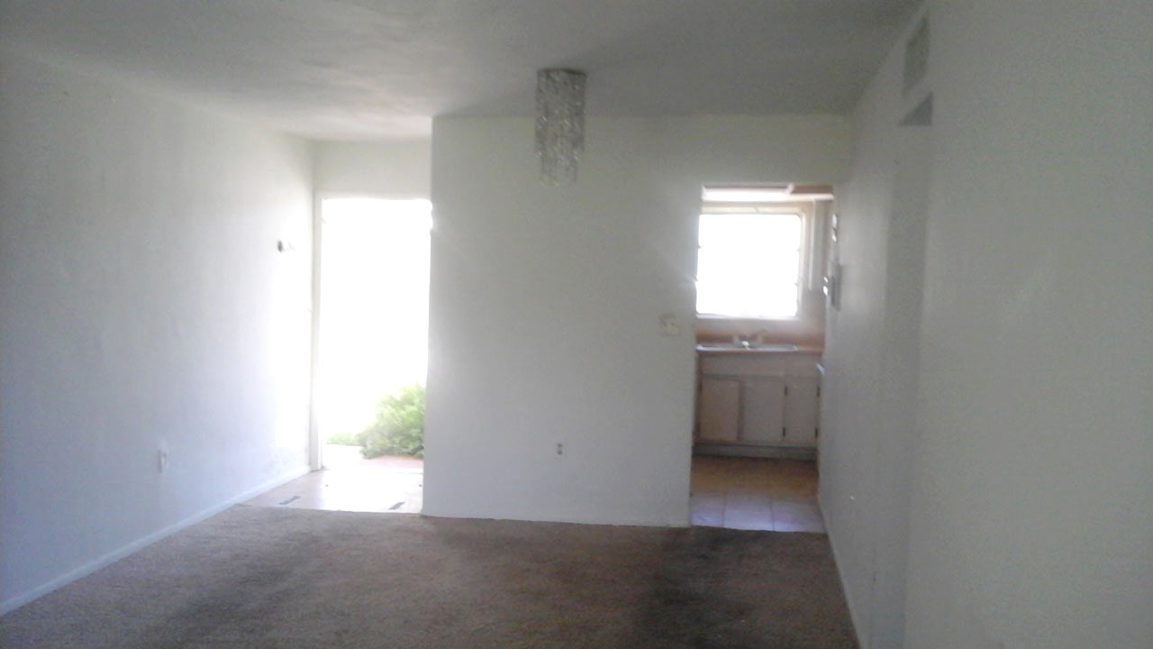 Before photo of foyer and living room.