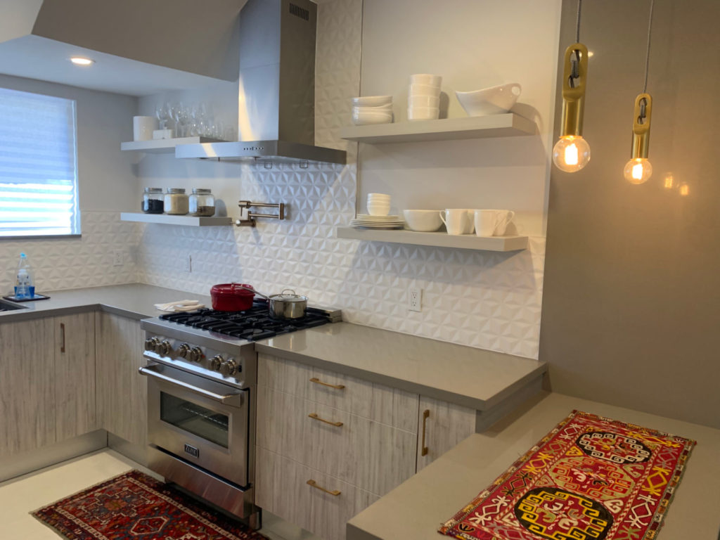 After photo of stainless-steel appliances and floating kitchen shelves