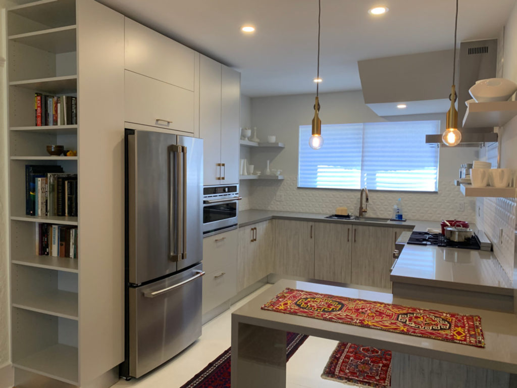 After photo of kitchen with waterfall counter, matte and wood-grain grey cabinets