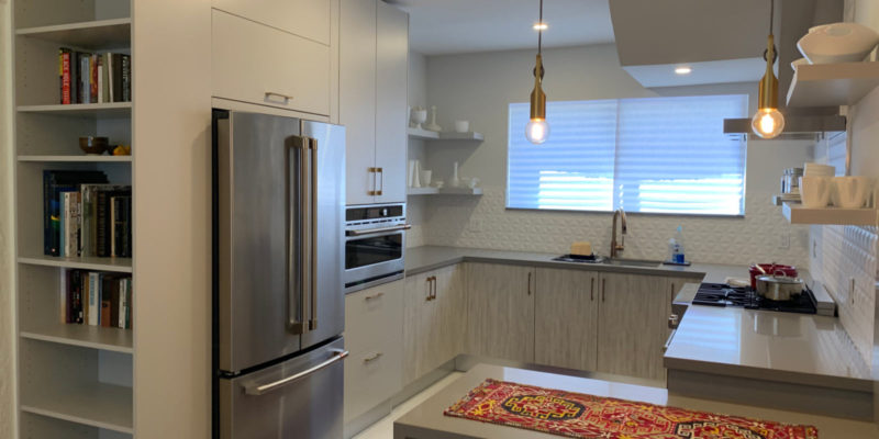 After photo of kitchen with waterfall counter, matte and wood-grain grey cabinets