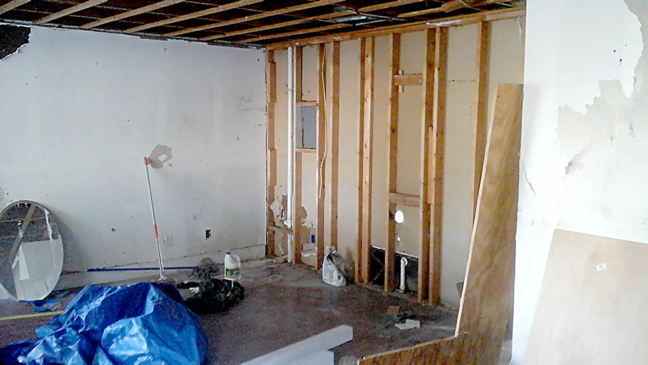 Before photo of vandalized plumbing and missing drywall